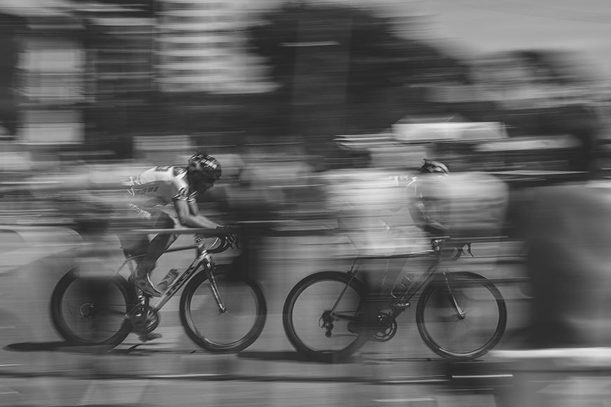 Black and white blurred image of two road bikes