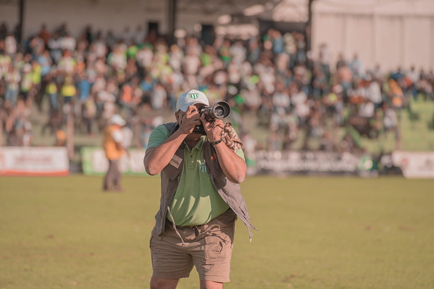 A man taking a photo at a sporting game