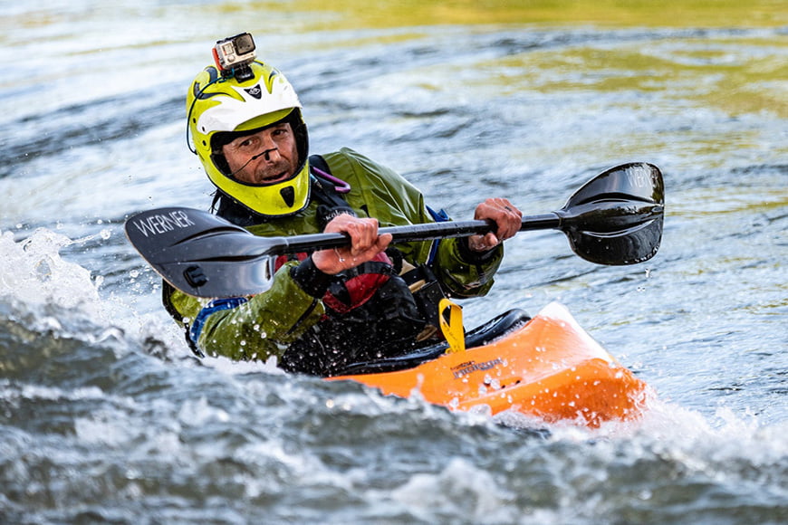 A man rafting with an action camera on his helmet