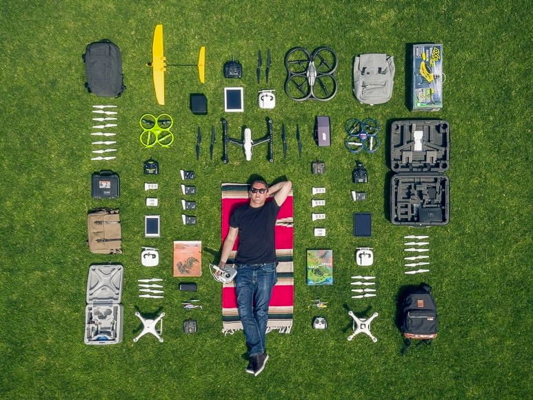 Man laying on the ground surrounded by photography equipment