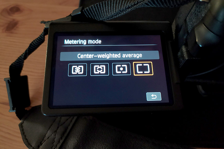 Camera screen showing metering mode menu set to center weighted.