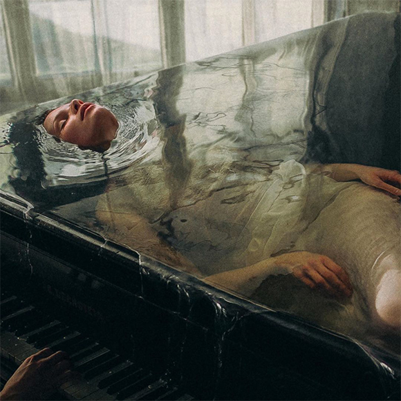 Incredible photo shoot of a model floating in a piano.