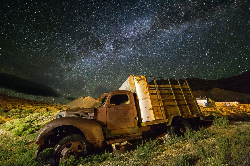 Starry night sky over and abandoned old truck