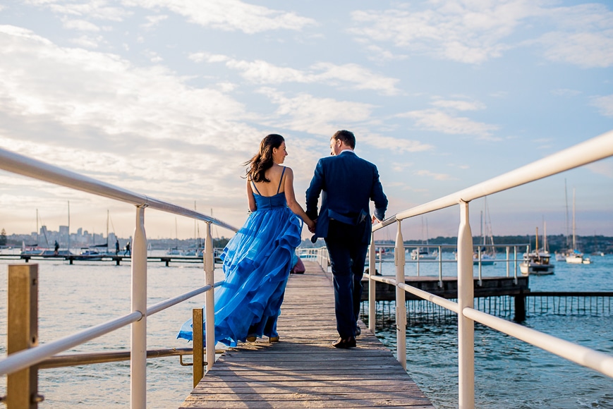 leading line photography - a couple walking along a straight jetty