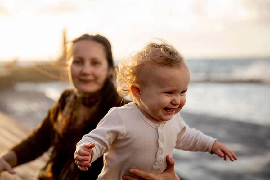 lifestyle photo of a women holding her happy baby