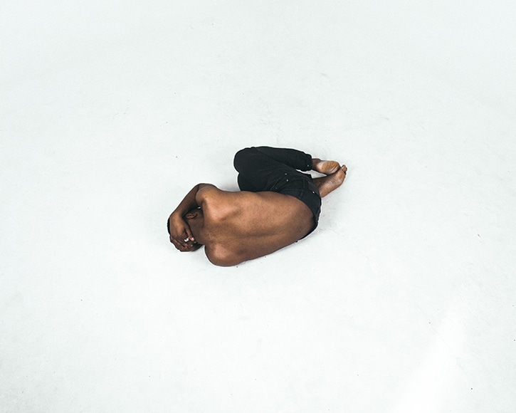 man lying on white floor