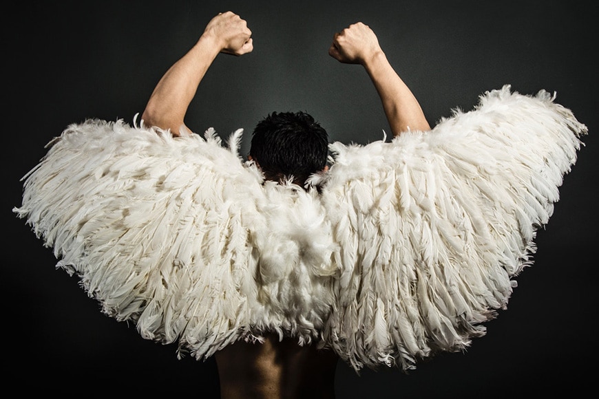 Man wearing white feather wings