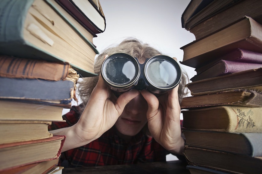 Man with binoculars and books