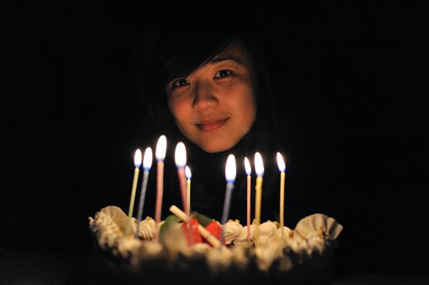 Girl holding birthday cake with candles