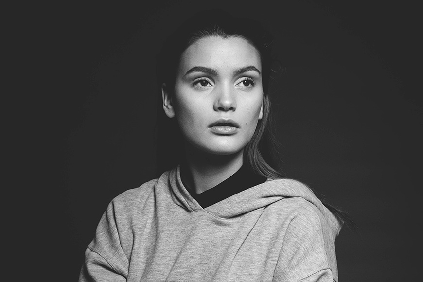Black and white photo of a women in a hooded jumper