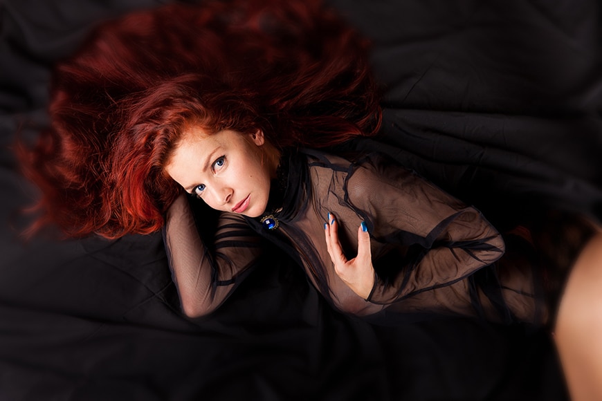 Redhead with hair splayed on bed
