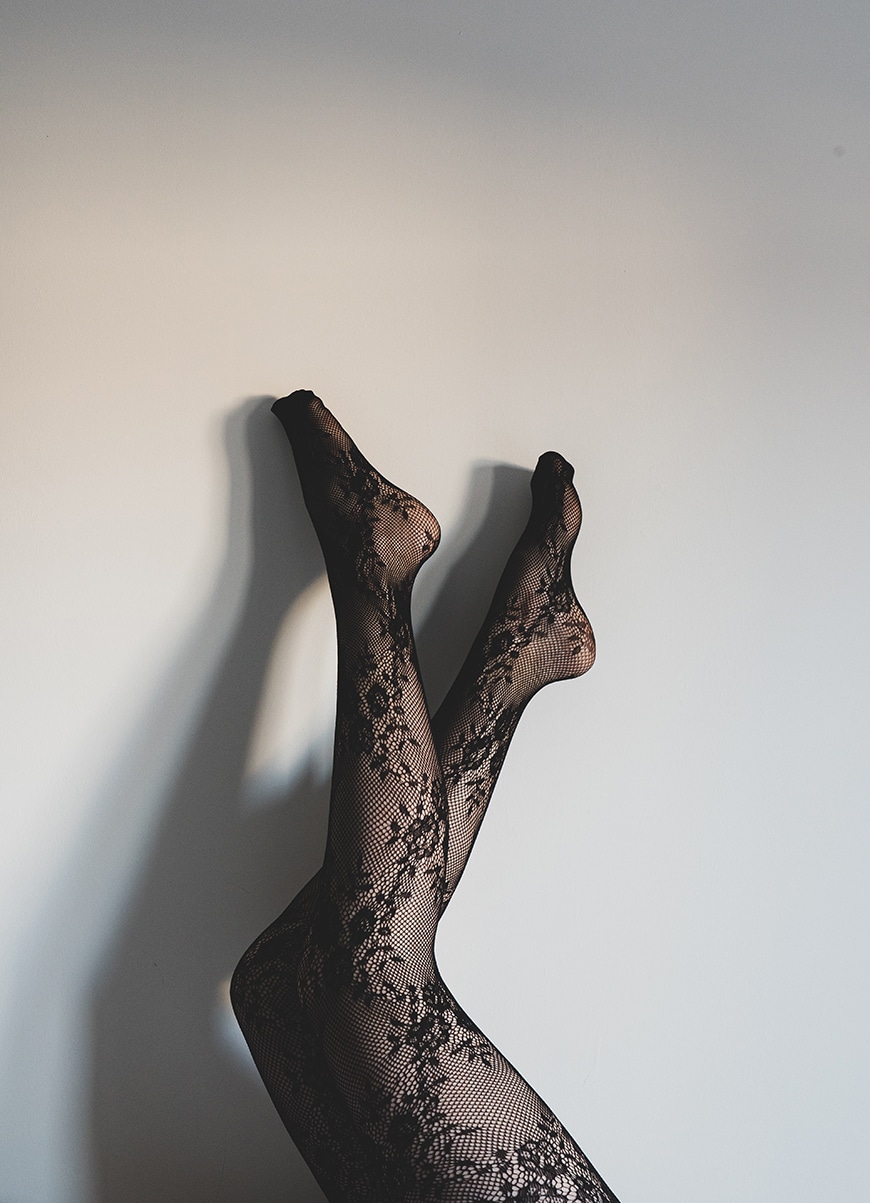 Lace tights with legs against the wall