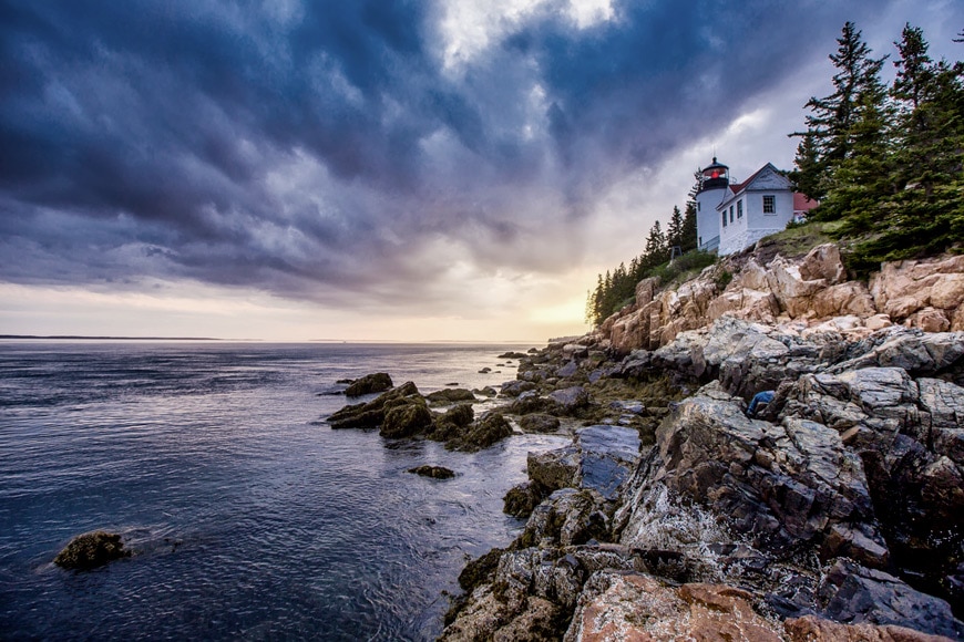 hdr image - moody dark clouds over coast line with a house