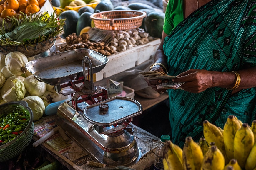 Woman at a fruit stall with weight scales