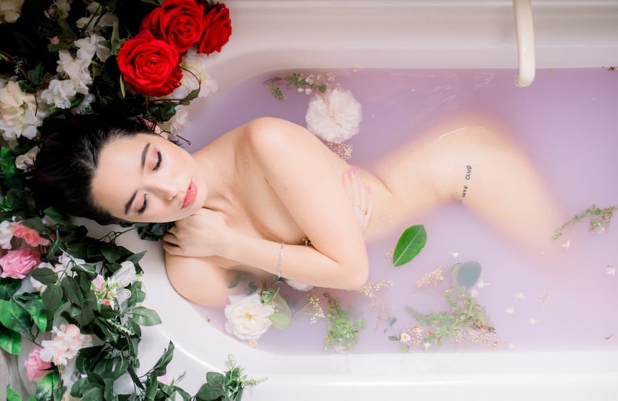 Female model in milk bath with flowers
