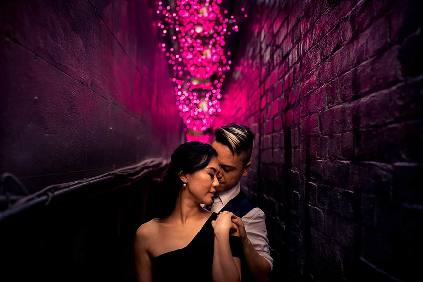 Couple in alleyway with pink lights