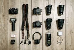 Various camera equipment laid out on a wooden floor.