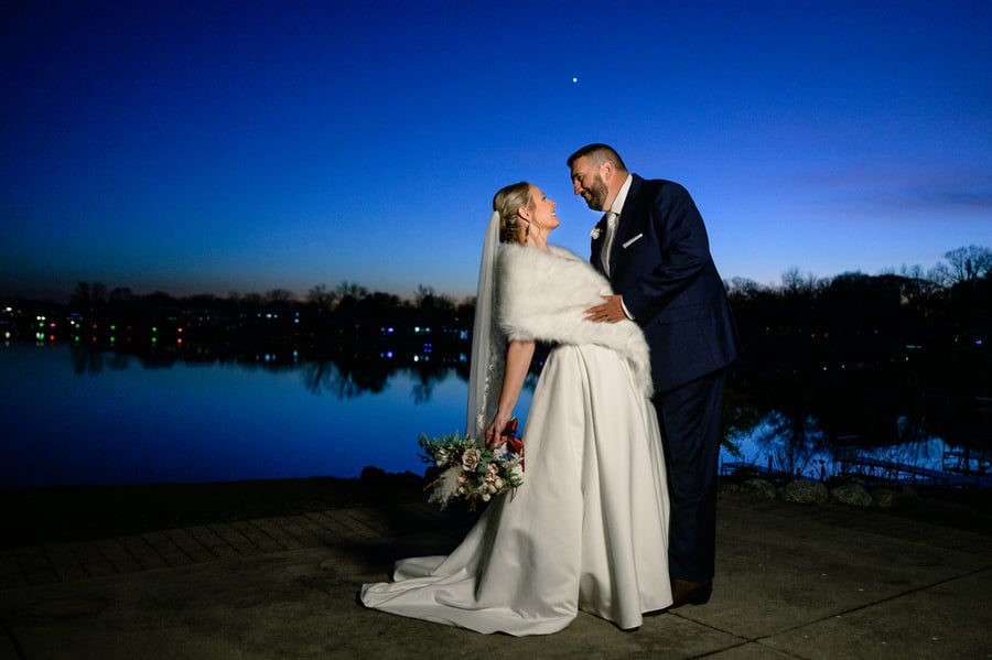 bride and groom holding eachother at night with blue sky