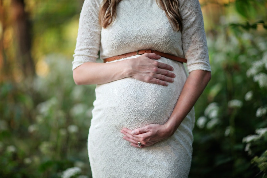 pregnant woman with husband posing in the city park, family portrait,  summer season, green grass and trees Stock Photo - Alamy