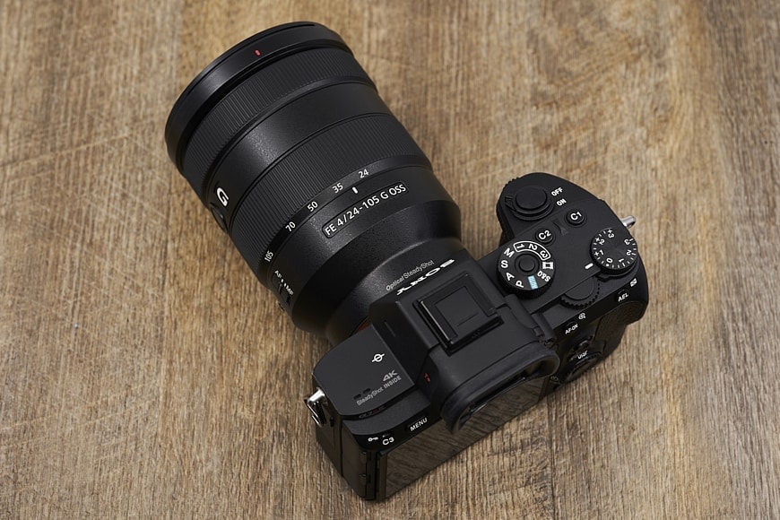 sony 24-105 lens attached to mirrorless camera on table