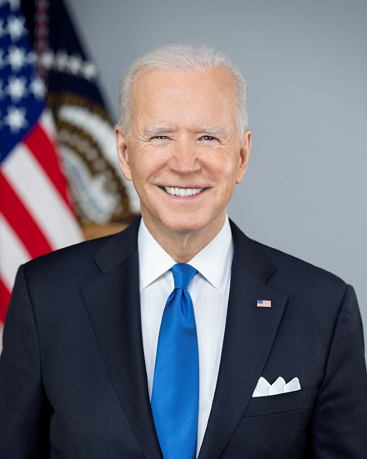 Joe Biden in suit in front of flag