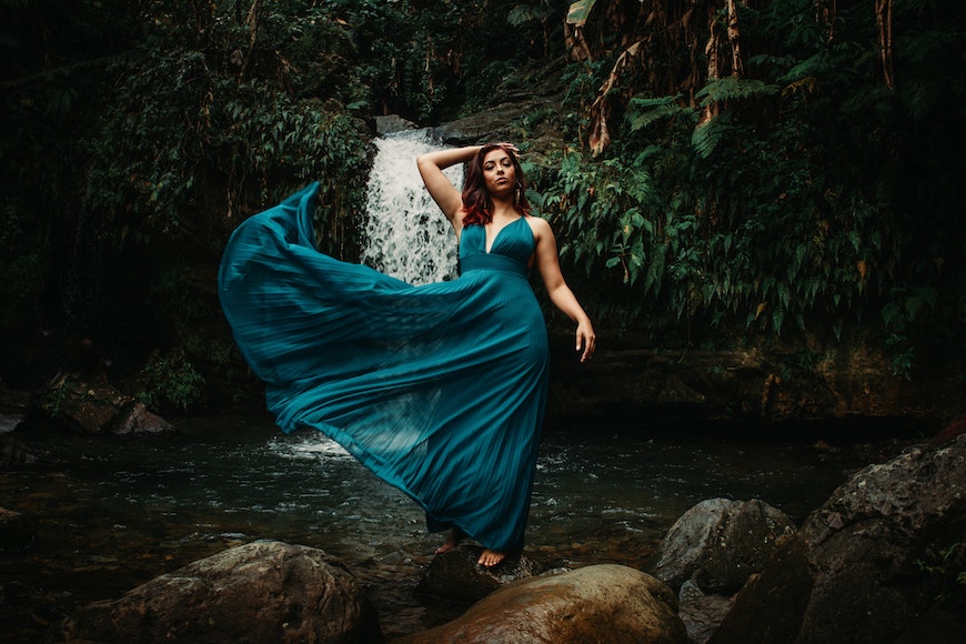 Girl in dress in front of waterfall