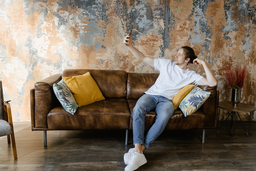 Man sitting on sofa taking selfie