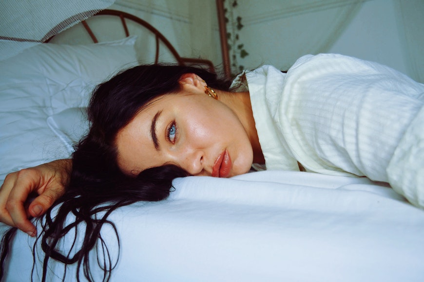 Blue eyed girl lying on bed