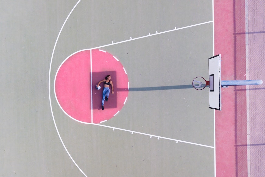 Girl lying in shadow on basketball court