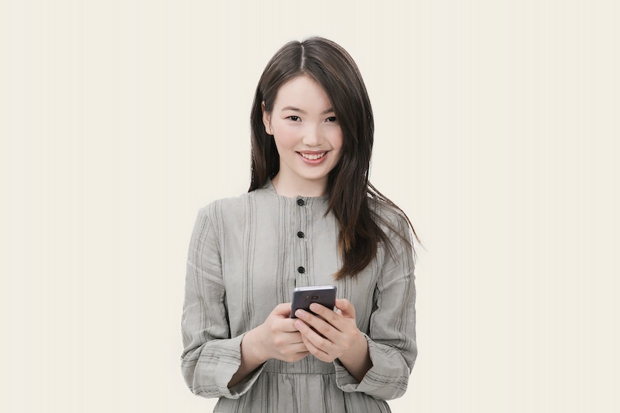 Girl in grey dress holding phone