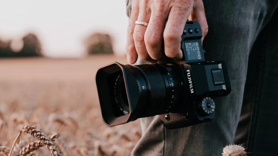 photographer holding fujifilm camera in the field