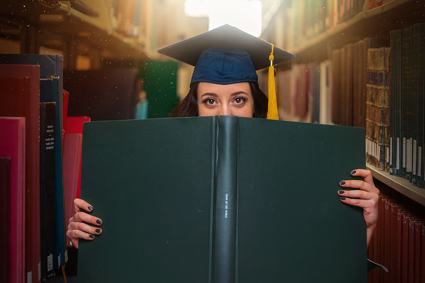 graduate peeking out from book