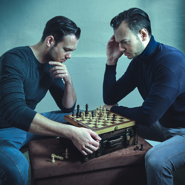 photo of two people playing chess