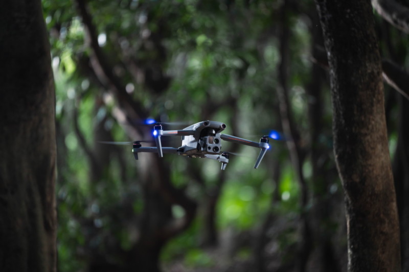 drone flying through forest