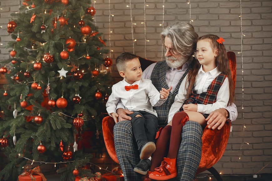 Grandpa with two children on lap at Christmas