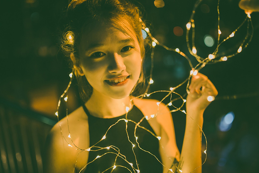 Night photo of a girl with fairy lights