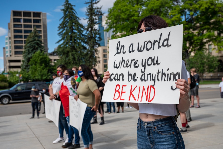 Person holding up a sign about kindness