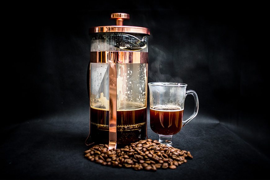 French press with coffee beans