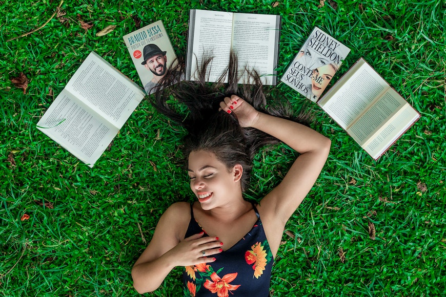 Lying on grass with books