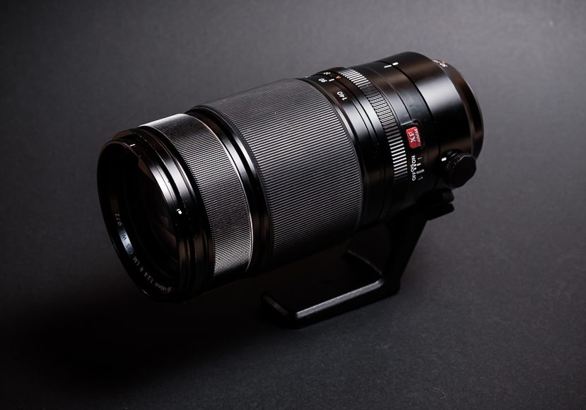 a close up of a fuji camera lens on a black surface.