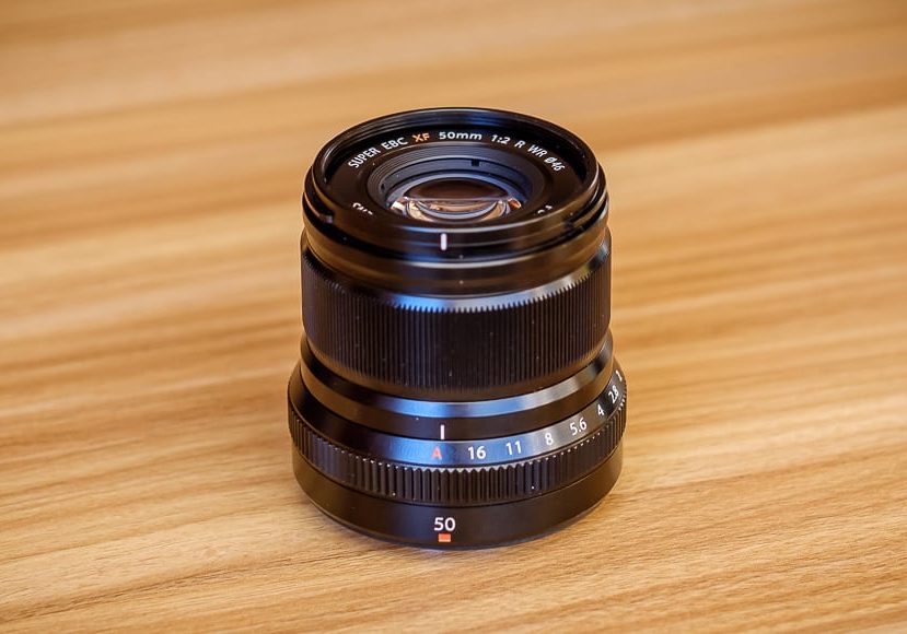 a camera lens sitting on top of a wooden table.