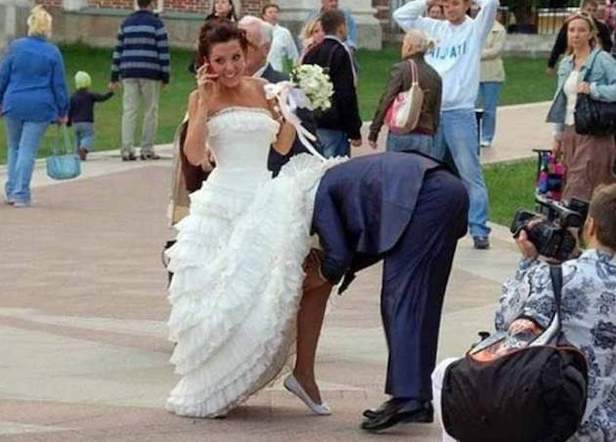 a man taking a picture of a woman in a wedding dress.