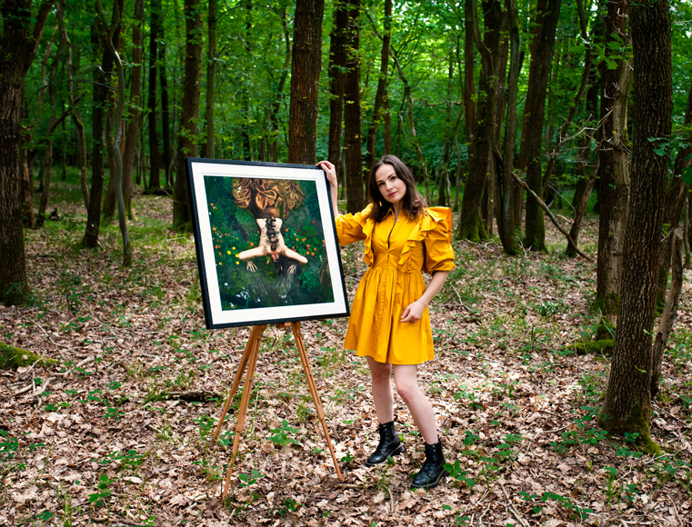 a woman in a yellow dress standing next to a picture of a tiger.