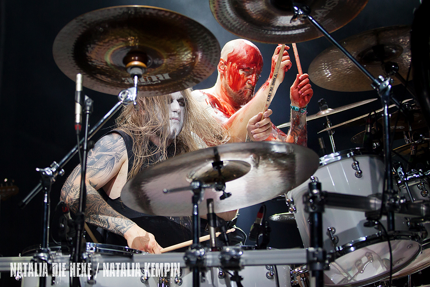 a man with a bloody face playing drums.