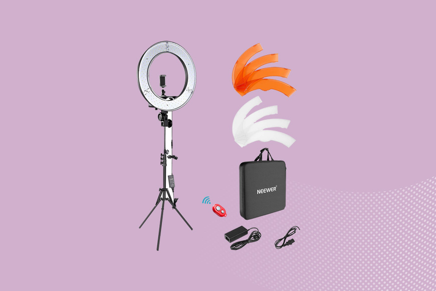 a tripod with a light and accessories on a pink background.