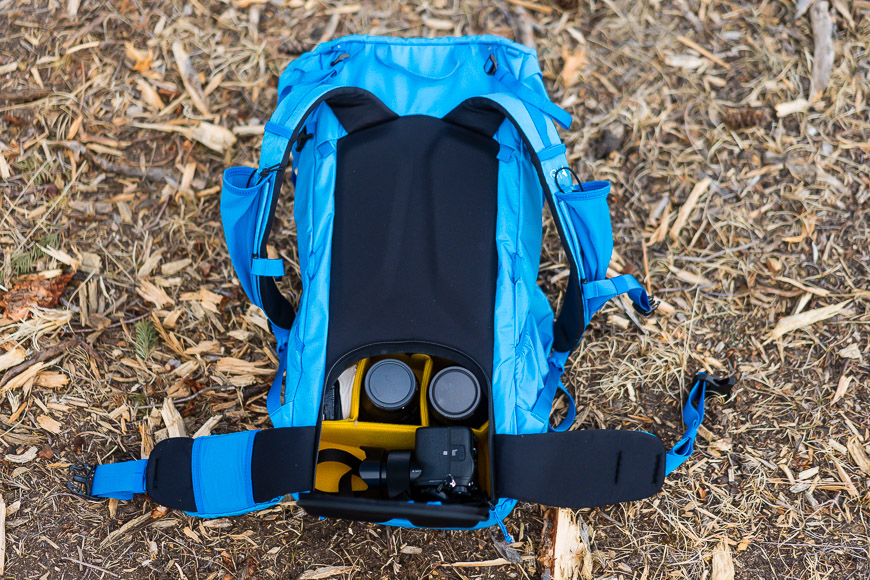a blue backpack sitting on top of dry grass.