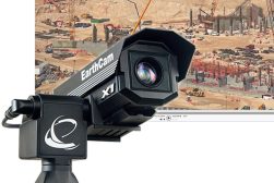 a camera is on a tripod in front of a construction site.