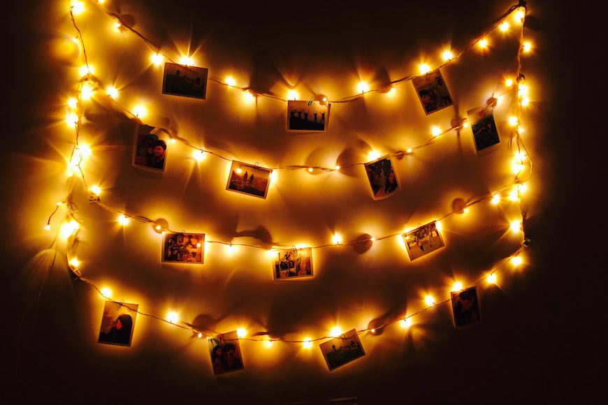 A string of lights with photos hanging on it.