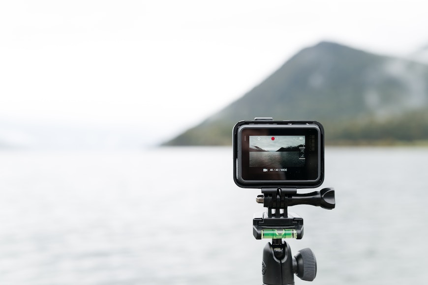 a go pro on a tripod overlooking the side of a body of water.