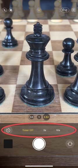 A screenshot of the iPhone camera app showing the timer menu options and depicting a close up of a chess board with pieces on it.